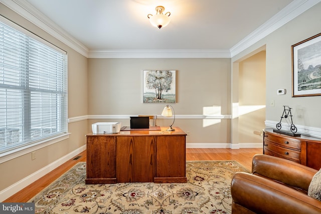 office with light wood-type flooring, visible vents, baseboards, and crown molding