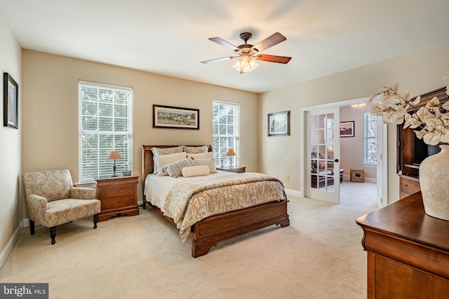 bedroom with baseboards, french doors, a ceiling fan, and light colored carpet