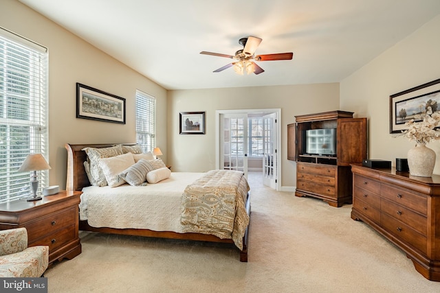 bedroom featuring multiple windows, baseboards, a ceiling fan, and light colored carpet