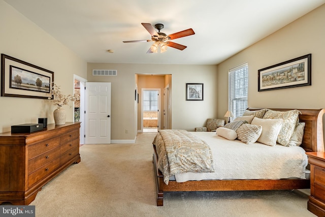 bedroom featuring light colored carpet, visible vents, ensuite bathroom, and multiple windows