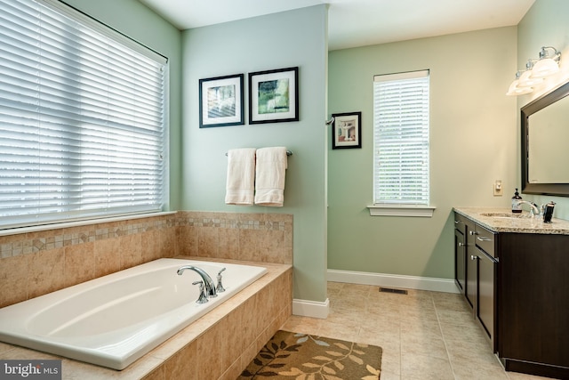 bathroom featuring tile patterned flooring, a garden tub, visible vents, vanity, and baseboards