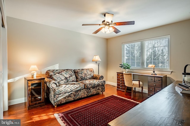 office space featuring a ceiling fan, baseboards, and wood finished floors