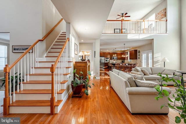 living room with ceiling fan, light wood finished floors, stairway, and recessed lighting