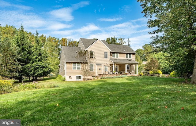 rear view of property with a lawn and a patio area