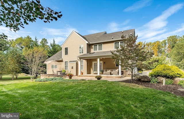 rear view of house with outdoor lounge area, a lawn, and a patio