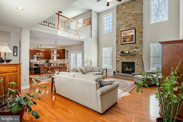 living room featuring light wood-type flooring, a fireplace, and plenty of natural light