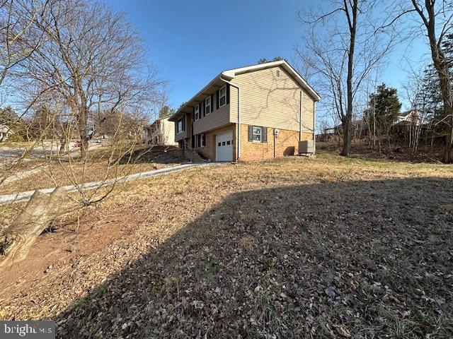 rear view of house with a garage and central AC unit