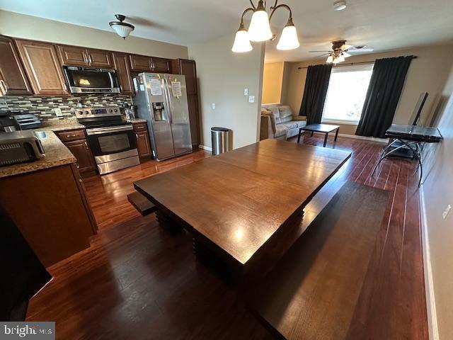 dining area with baseboards, dark wood finished floors, and a ceiling fan