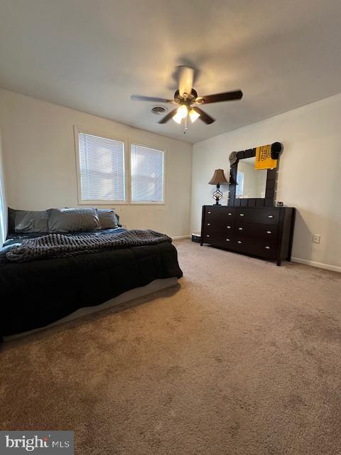 carpeted bedroom featuring a ceiling fan and baseboards