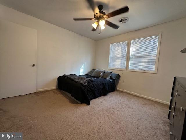 carpeted bedroom featuring visible vents, baseboards, and ceiling fan