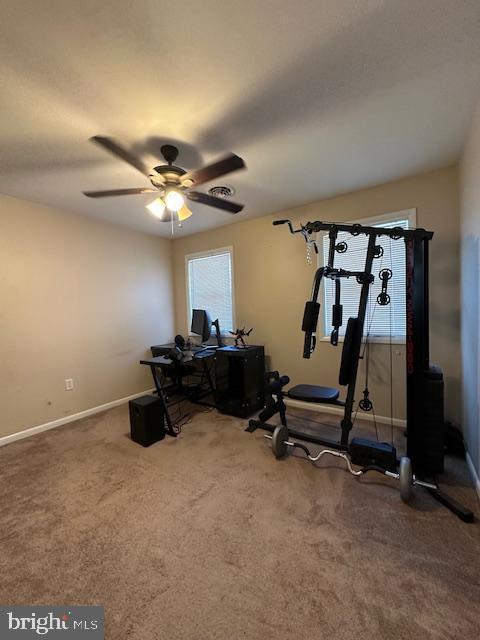 workout room with ceiling fan, baseboards, and carpet