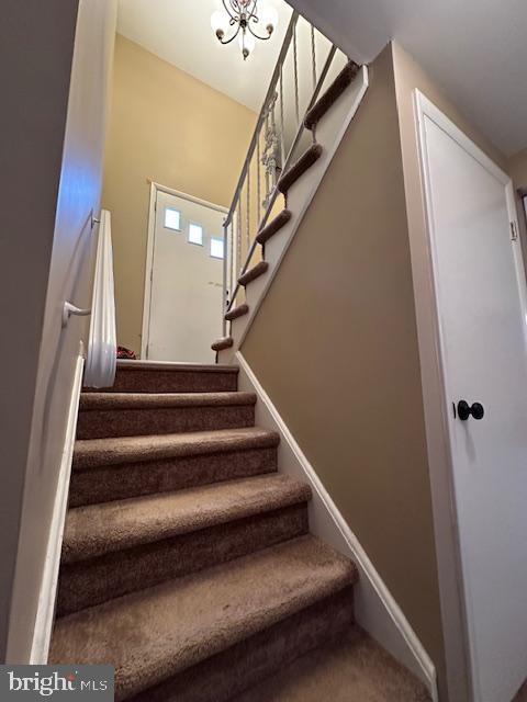 stairway featuring carpet flooring and baseboards