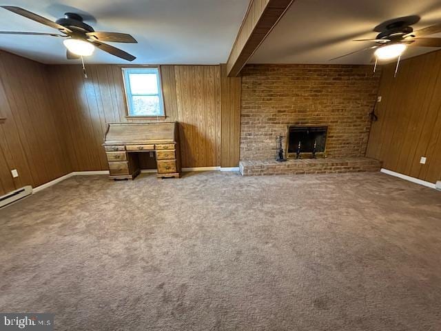 unfurnished living room with carpet floors, wood walls, and a fireplace