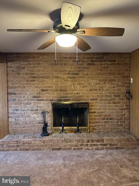 interior details featuring a fireplace, carpet, and a ceiling fan