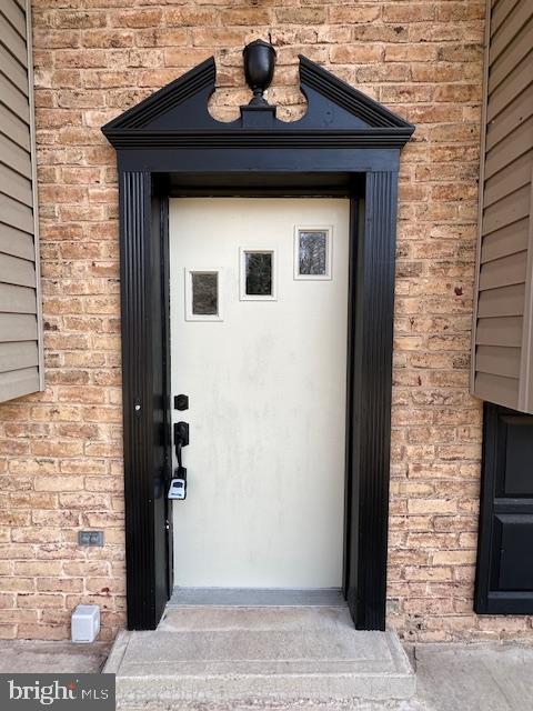 property entrance featuring brick siding