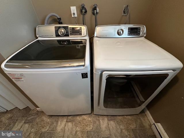 laundry area featuring laundry area, independent washer and dryer, a baseboard radiator, and wood tiled floor