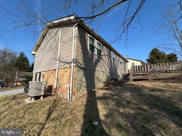 view of side of home featuring central AC unit and a wooden deck