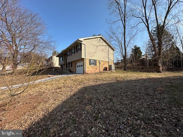 view of home's exterior with an attached garage and brick siding