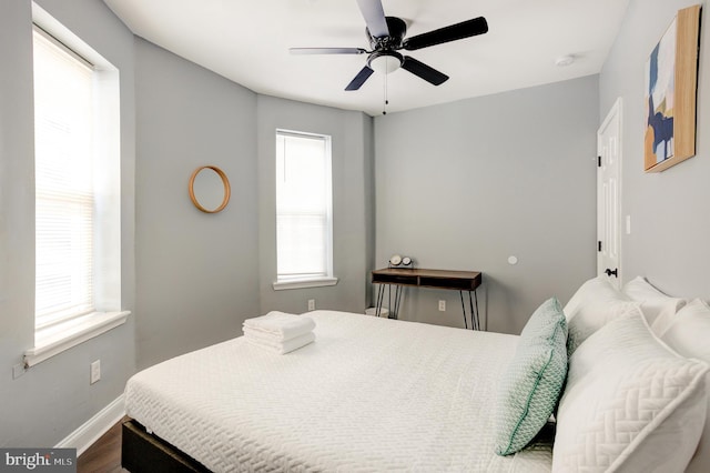 bedroom featuring a ceiling fan, baseboards, and wood finished floors