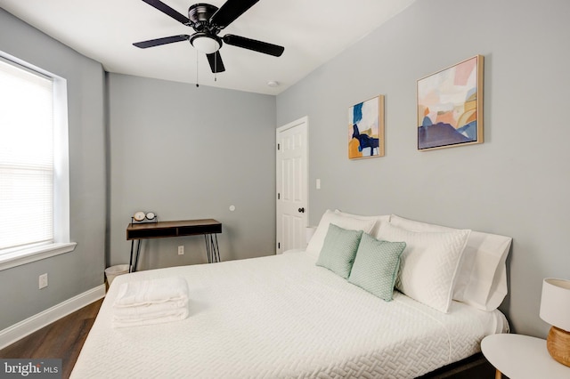 bedroom featuring a ceiling fan, baseboards, and dark wood-style flooring