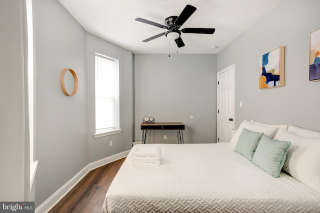 bedroom featuring dark wood-style flooring, a ceiling fan, and baseboards