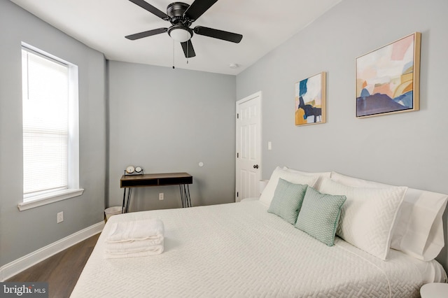 bedroom with a ceiling fan, baseboards, and dark wood-style flooring