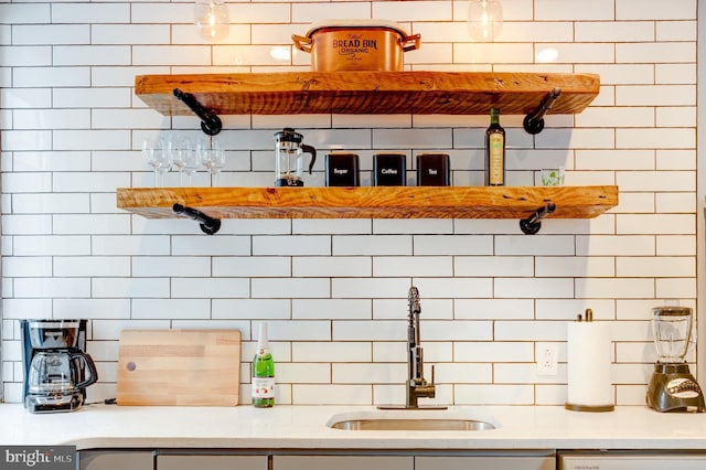 interior space with light countertops, a sink, and decorative backsplash