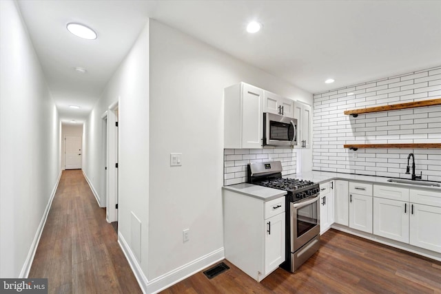 kitchen with open shelves, visible vents, appliances with stainless steel finishes, dark wood-type flooring, and a sink