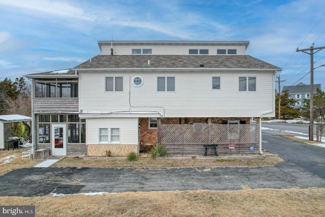 exterior space with brick siding and a sunroom