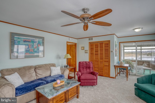 living area with visible vents, a ceiling fan, carpet flooring, and crown molding