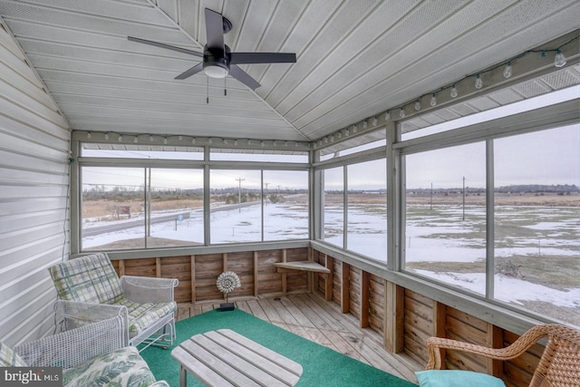 unfurnished sunroom featuring lofted ceiling and a ceiling fan