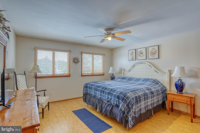 bedroom with ceiling fan, baseboards, and wood finished floors