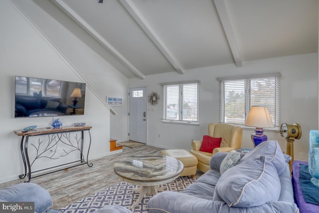 living room featuring lofted ceiling with beams, baseboards, and wood finished floors