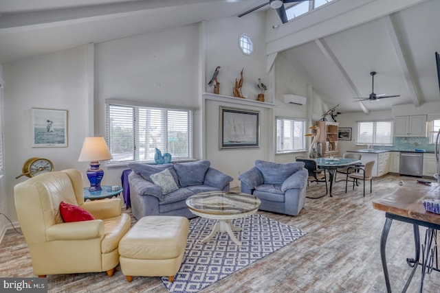 living area featuring beamed ceiling, an AC wall unit, ceiling fan, and light wood-style flooring