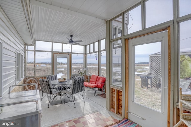 sunroom / solarium featuring a ceiling fan