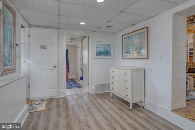 corridor featuring wood finished floors, visible vents, and baseboards