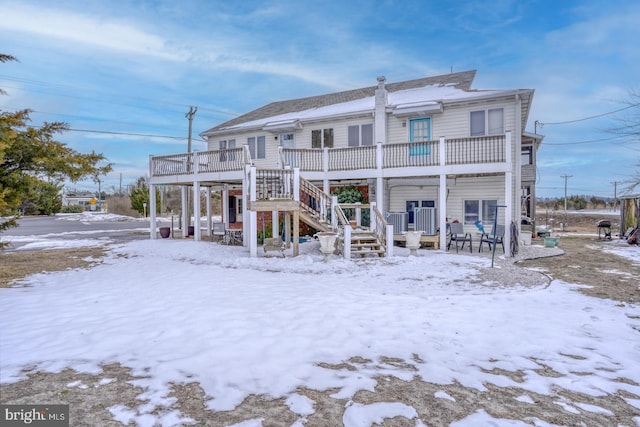 snow covered rear of property featuring a deck