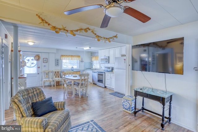 living area with light wood-style floors and ceiling fan