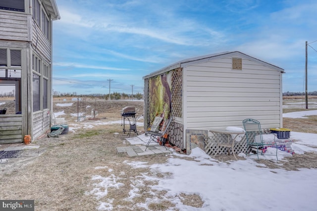 snow covered property featuring an outdoor structure