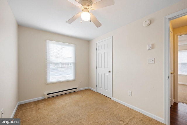 unfurnished bedroom featuring carpet, baseboards, multiple windows, and baseboard heating