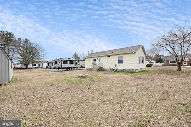 back of property featuring a fire pit and crawl space