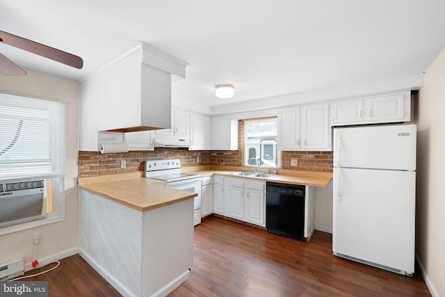 kitchen featuring white appliances, light countertops, a sink, and a peninsula