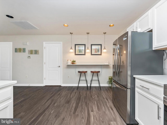 kitchen featuring a breakfast bar, dark wood finished floors, white cabinetry, and baseboards