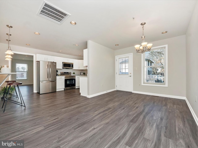 interior space with stainless steel appliances, dark wood-style flooring, visible vents, and white cabinetry