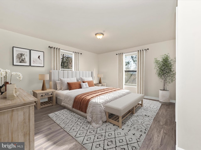 bedroom featuring light wood finished floors, multiple windows, and baseboards