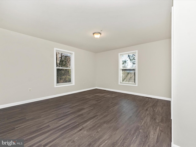 empty room with baseboards and dark wood finished floors