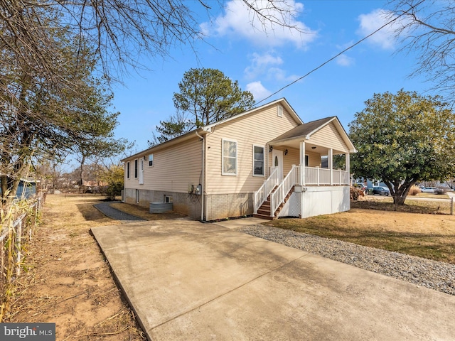 view of front of home featuring covered porch, stairway, and central AC