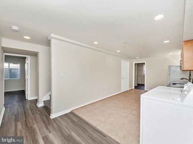 washroom with cabinet space, baseboards, washer and dryer, a sink, and recessed lighting