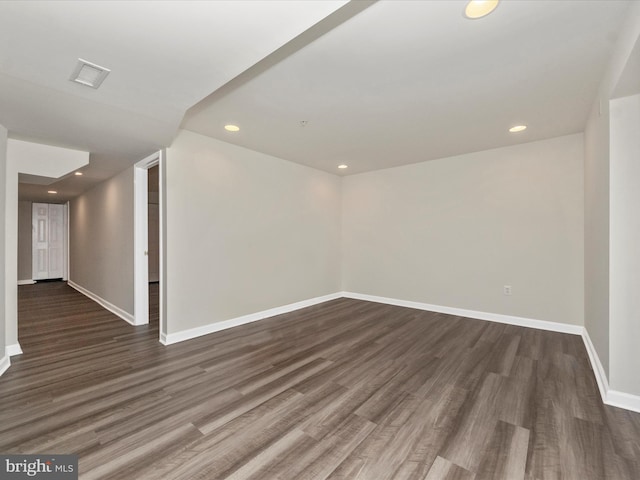 unfurnished room featuring recessed lighting, dark wood finished floors, visible vents, and baseboards