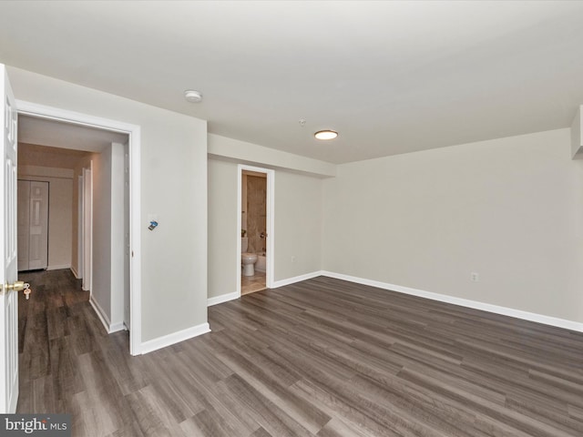 spare room featuring dark wood finished floors and baseboards